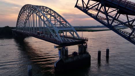 Die-Stahlbrücke-über-Den-Fluss-Noord-Senkt-Sich-In-Der-Ferne-Als-Sonnenuntergänge-Ab