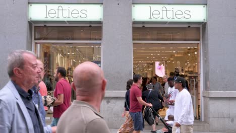 Customers-and-pedestrians-shop-at-the-Spanish-fashion-brand-owned-by-Inditex,-Lefties,-store-in-Spain