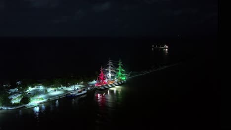 Italian-historical-sailing-ship-Amerigo-Vespucci-moored-at-night-in-Dominican-Republic-with-flag-colors