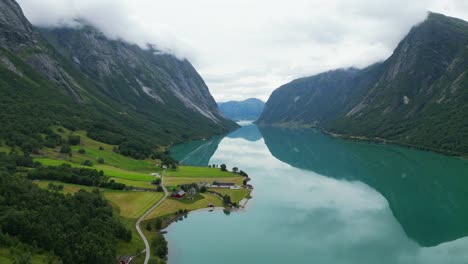 Fiordo-De-Noruega---Lago-Jolstravatn-Azul-Turquesa-Y-Pequeña-Aldea-Agrícola-Sygnesand-En-Sunnfjord,-Vestland---Antena