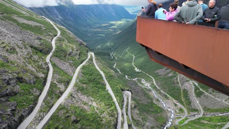 Trollstigen-Mountain-Pass-in-Norway---Tourist-People-taking-photos-at-Viewpoint-Platform---Tilting-Down