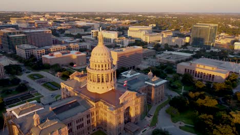 Downtown-Austin,-Texas-State-Capital-Building,-Drone-Flying-Around-Goddess-of-Liberty-Statue-on-Top-with-Views-Downtown-Buildings-and-The-University-of-Texas-at-Austin-Campus-Skyline-at-Sunset