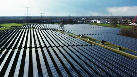 Cinematic-aerial-shot-of-solar-panels-in-grass-field-in-the-Netherlands