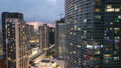 Edificios-Del-Horizonte-Del-Centro-De-Miami-Al-Atardecer-Iluminados-Con-Luz,-Tiro-Revelador-En-Cámara-Lenta