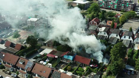 Aerial-shot-of-a-fire-burning-in-a-Dutch-shed-located-in-a-neighbourhood