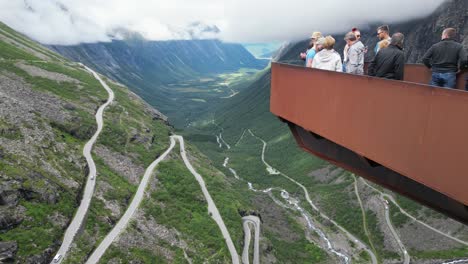 Trollstigen-Mountain-Pass-in-Norway---Tourist-People-taking-photos-at-Viewpoint-Platform---Pan-Left