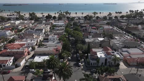 Long-Beach,-California---flying-over-homes-and-businesses-toward-the-beach