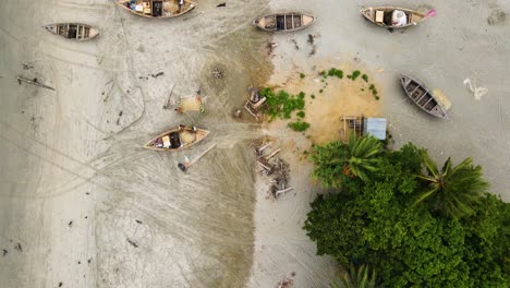 Fishermen-With-Wooden-Boats-Repairing-Their-Fishing-Nets-In-Tropical-Shoreline-Of-Kuakata-Sea-Beach,-Bangladesh