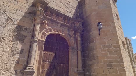 Tilt-up-reveal-of-Iglesia-de-San-Mateo's-facade-in-Cáceres,-Spain