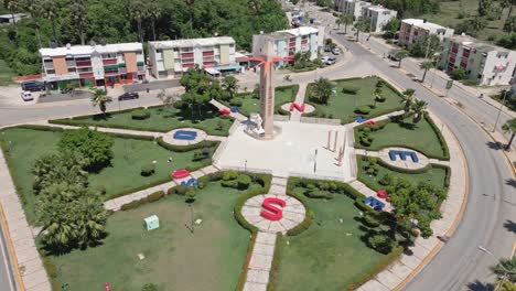 Aerial-orbiting-shot-of-DESORIENTADOS-Square-in-San-Juan-City-during-sunny-day,-Dominican-Republic