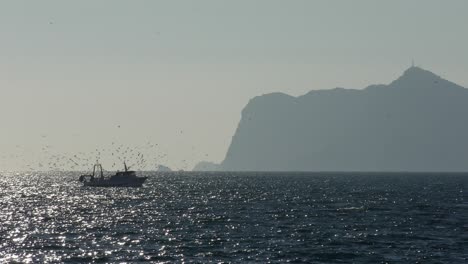Calpe-Spain-fishing-boat-returning-to-harbour-late-afternoon-on-a-winter-day