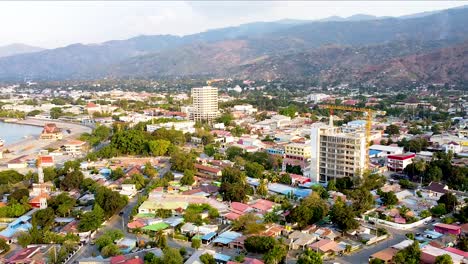 Vista-Aérea-Estática-Del-Paisaje-De-Drones-De-La-Ciudad-Capital-De-Dili,-Timor-Oriental-En-El-Sudeste-Asiático,-Con-Nuevos-Desarrollos-De-Edificios-De-Gran-Altura-Y-Casas-Residenciales.