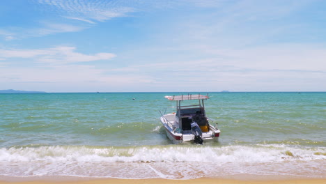 Ein-Boot-Mit-Außenbordmotor-Liegt-Ganz-In-Der-Nähe-Des-Strandes-Und-Bewegt-Sich-Mit-Den-Wellen-In-Pattaya,-Thailand,-Weltberühmt-Für-Seine-Strände-Und-Resorts
