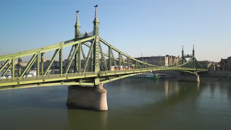 Die-Luftaufnahme-Zeigt-Die-Freiheitsbrücke-In-Budapest,-Während-Der-Zug-Die-Brücke-überquert