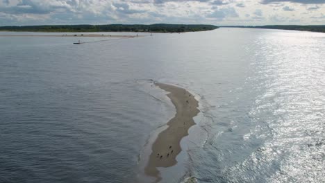 Drone-shot-backwards-over-a-sand-island-of-a-large-herd-of-grey-seals