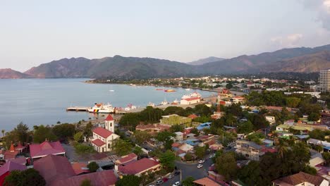 Scenic-aerial-view-of-urban-capital-city-of-Dili,-Timor-Leste-in-Southeast-Asia-with-hills,-streets,-traffic,-buildings,-churches-and-ocean