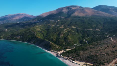 Scenic-Albanian-Riviera-in-Lukova:-Olive-Tree-Covered-Hills,-Majestic-Mountains,-Sun-Kissed-Beaches,-and-the-Azure-Beauty-of-the-Ionian-Sea