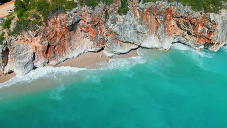 Aerial-drone-forward-moving-shot-over-steep-rocky-cliffs-along-Gjipe-Beach,-Albania-on-sunny-day