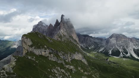 Seceda-Mountains-in-the-Italian-Dolomites-with-the-clouds-covering-the-steep-pinnacle-shaped-cliffs