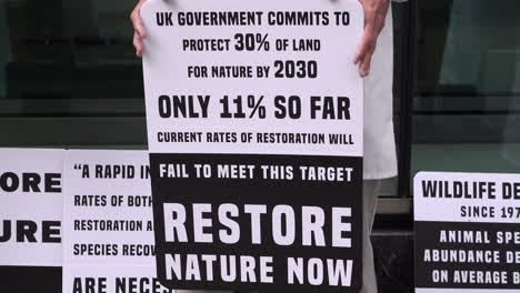Un-Cartel-De-Un-Manifestante-Dice:-“El-Gobierno-Del-Reino-Unido-Se-Compromete-A-Proteger-El-30%-De-La-Tierra-Para-La-Naturaleza-Para-2030