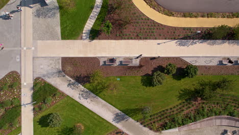 Top-down-aerial---several-paths-in-the-park,-modern-infrastructure-in-the-park,-greenery-and-development-of-urban-area