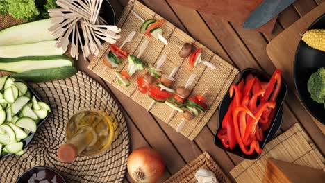 Vegetable-skewers-lie-on-a-wooden-board-surrounded-by-ingredients