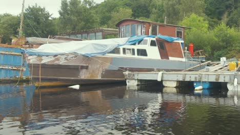 Wooden-motor-cruiser-being-restored-while-moored-to-dock