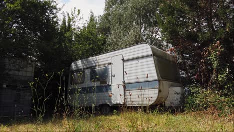 Old-disused-and-neglected-caravan-sits-isolated-surrounded-by-vegetation