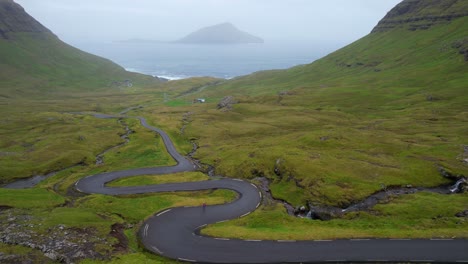 Woman-stopped-on-winding-road-Nordadalsskard-in-Faroe-Islands