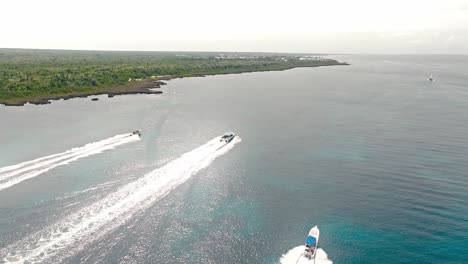 Speedboats-navigating-together-in-the-same-direction-along-Bayahibe-coast-leaving-white-wakes,-Dominican-Republic
