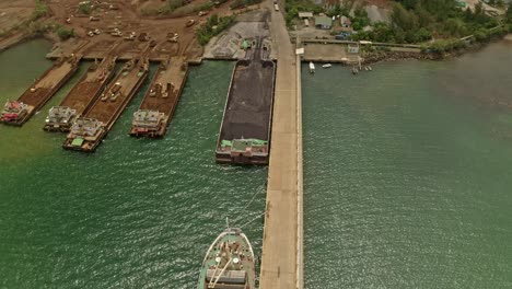 Large-barges-docked-in-Taganito,-Philippines-collecting-material-from-the-Nickel-Mines