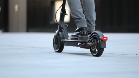 Un-Joven-Empresario-Conduce-Su-E-scooter-Por-La-Ciudad,-De-Cerca