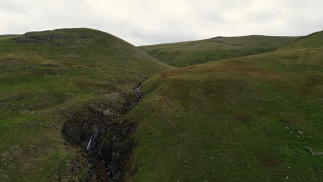 Long-zoom-out-from-waterfall-running-down-hillside