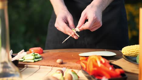 close-up-of-a-young-man-preparing-vegetable-skewers-for-grilling