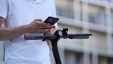 close-up-of-a-young-businessman-activating-an-e-scooter-with-his-phone