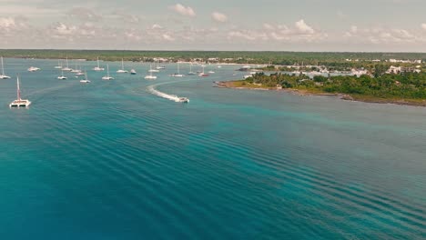 Motorboat-exiting-from-Bayahibe-port-and-navigating-on-blue-sea-waters,-La-Romana-in-Dominican-Republic