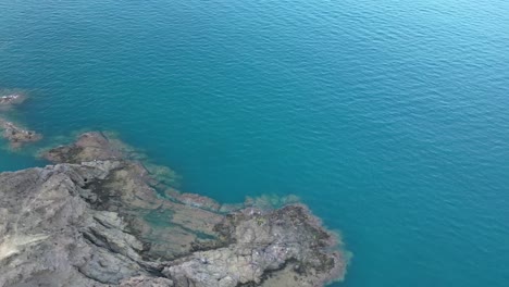Eine-Perspektive-Von-Oben-Auf-Eine-Felsige-Klippe-Und-Das-Azurblaue-Meer