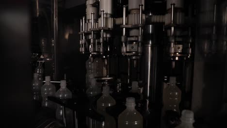 Empty-Plastic-Vinegar-Bottles-Being-Filled-with-Fresh-Vinegar-at-a-Factory-on-a-Rotating-Machine