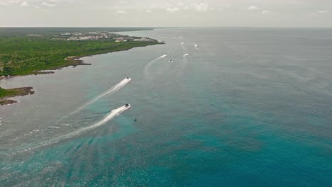 Many-speedboats-cruising-along-Bayahibe-lush-coast,-La-Romana-in-Dominican-Republic