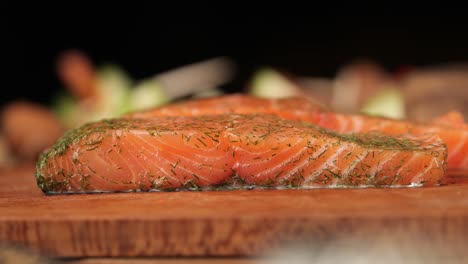 Slow-motion-shot-of-a-piece-of-salmon-lying-on-a-wooden-board-close-up