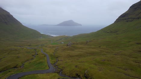 Isla-Koltur-En-La-Niebla-Con-Un-Automóvil-Pasando-Por-Una-Mujer-Revelada,-Islas-Feroe
