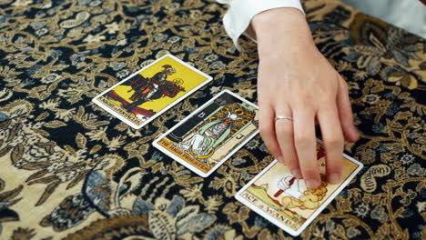 A-woman-giving-a-tarot-reading-with-the-knight-of-pentacles-the-high-priestess-and-the-ace-of-wands-cards