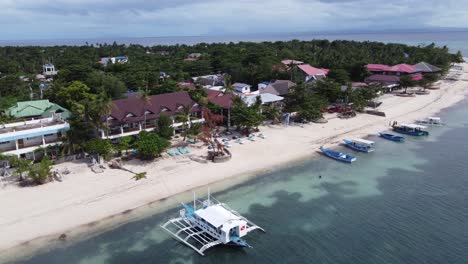 Barco-De-Buceo-Con-Estabilizadores-Amarrado-En-Resorts-De-Buceo-Frente-Al-Mar-En-La-Isla-De-Malapascua,-Filipinas