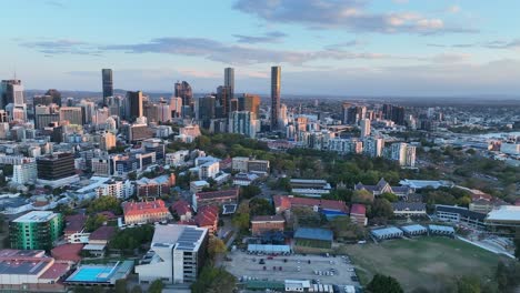 Aerial-shot-of-Brisbane-City,-camera-flying-past-Brisbane-Girls-Grammar-School,-Roma-St-Parklands,-towards-Brisbane-CBD-and-River