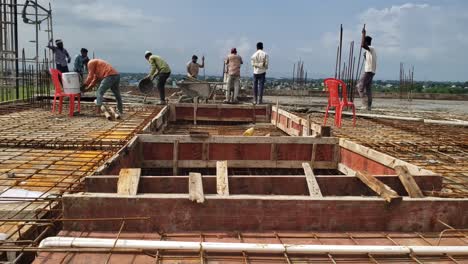 Bauarbeiter-Konstruieren-Bei-Bauarbeiten-In-Indien-Ein-Metallgerüst-Und-Gießen-Beton-Auf-Die-Platte