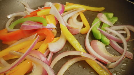 Sauteing-Sliced-Onions-with-Red,-Green,-and-Yellow-Bell-Peppers-on-a-Non-Stick-Pan
