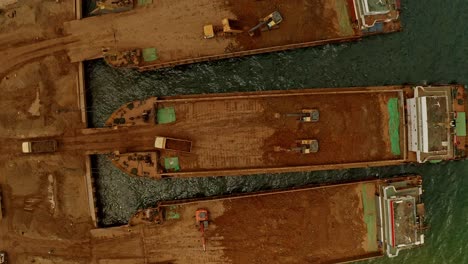 Top-down-view-of-mining-barges-being-loaded-in-Taganito,-Claver,-Philippines