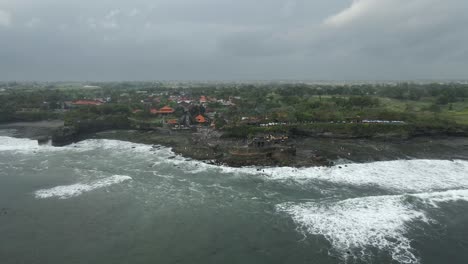 Panorámica-De-Luz-Plana-Y-Nublada-A-Través-De-Rocas-Costeras-En-El-Templo-De-Tanah-Lot-En-Bali.