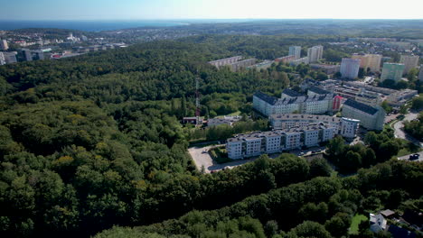 Aerial-flyover-forest-landscape-and-polish-neighborhood-with-apartment-blocks-in-Witomino,-Gdynia-City