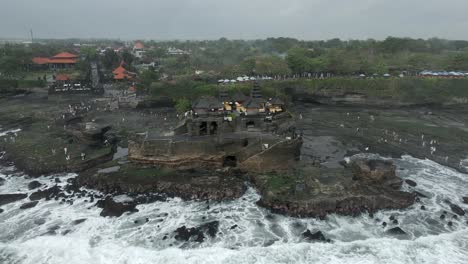 Flat-light-grey-day-aerial-view-of-Tanah-Lot-Hindu-Temple,-Bali-coast